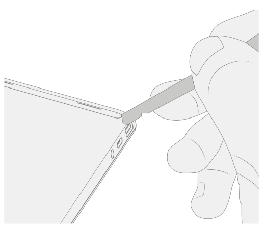 A spudger pries up a foot beside the ventilation grille on a Surface Laptop Go 2.