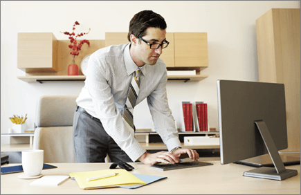 Photograph of a man working at a computer.