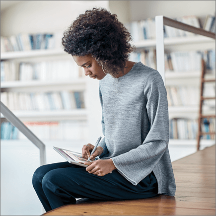 Photograph of a woman working on a Surface tablet computer.